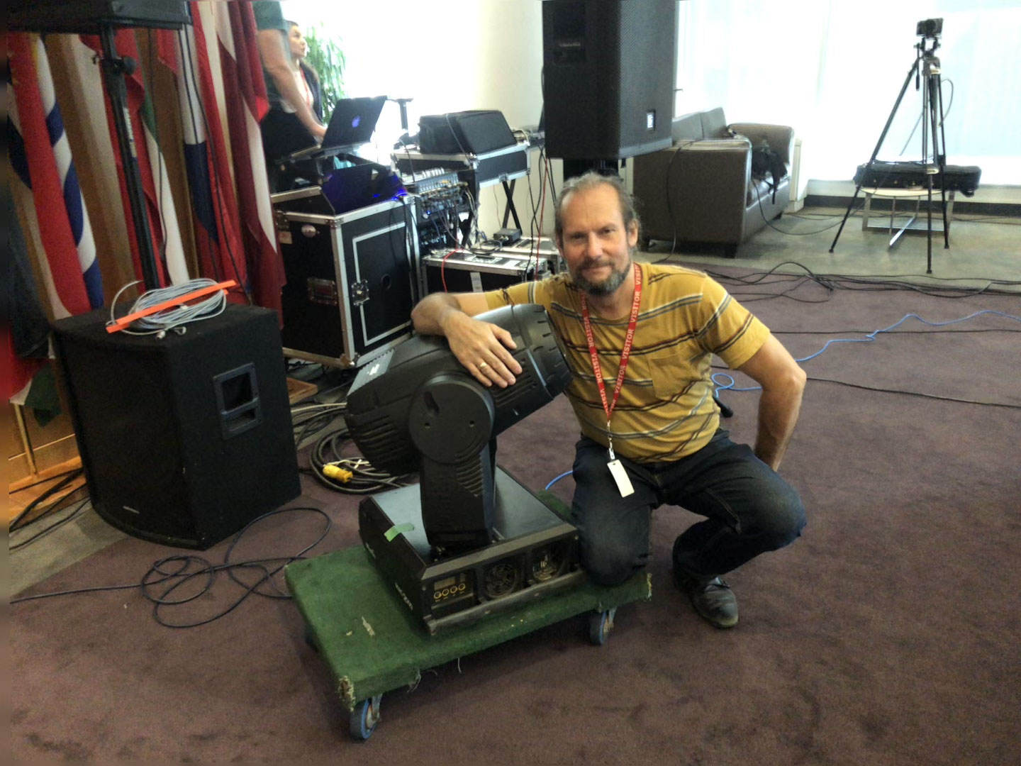 Lighting technician posing with stage lighting equipment at an event venue